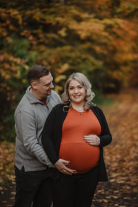 husband smiles at pregnant wife during maternity photoshoot