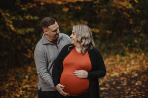 pregnant wife smiles at her husband in ormeau park.